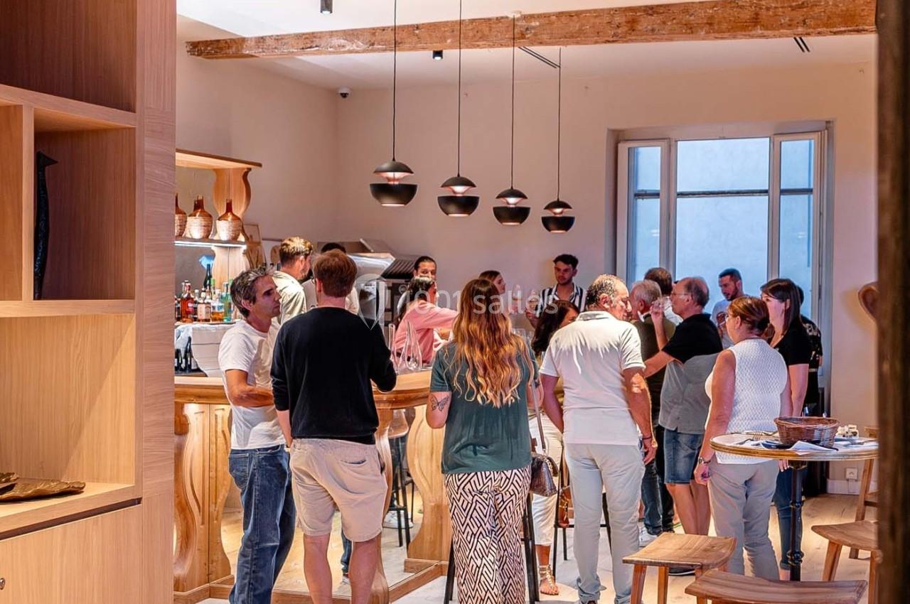 Groupe de personnes discutant dans un bar à l'intérieur d'un espace lumineux avec des éléments en bois.