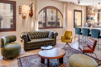 Seau à champagne avec bouteilles et deux verres sur une table en marbre, fauteuil en cuir en arrière-plan.