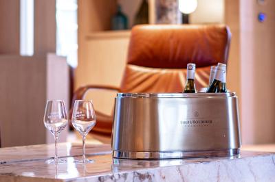 Seau à champagne avec bouteilles et deux verres sur une table en marbre, fauteuil en cuir en arrière-plan.