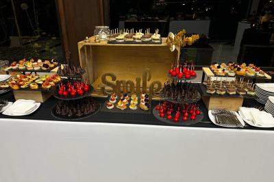 Buffet de desserts variés avec gâteaux, brochettes sucrées et verrines, présenté sur une table décorée.