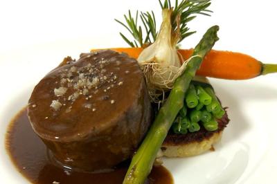 Bouteille de champagne et flûtes remplies d'un cocktail bleu, disposées sur une table en extérieur.