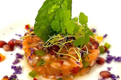 Bouteille de champagne et flûtes remplies d'un cocktail bleu, disposées sur une table en extérieur.