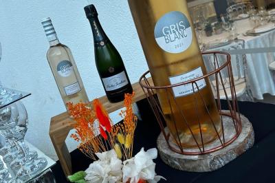 Bouteille de champagne et flûtes remplies d'un cocktail bleu, disposées sur une table en extérieur.