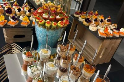 Bouteille de champagne et flûtes remplies d'un cocktail bleu, disposées sur une table en extérieur.