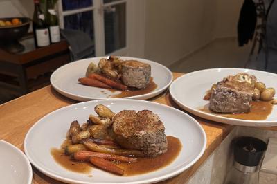 Assiette gastronomique composée de crevettes, légumes, pommes de terre et perles de sauce, présentée avec soin.