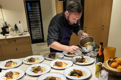 Assiette gastronomique composée de crevettes, légumes, pommes de terre et perles de sauce, présentée avec soin.