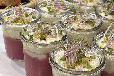 Assiette gastronomique composée de crevettes, légumes, pommes de terre et perles de sauce, présentée avec soin.