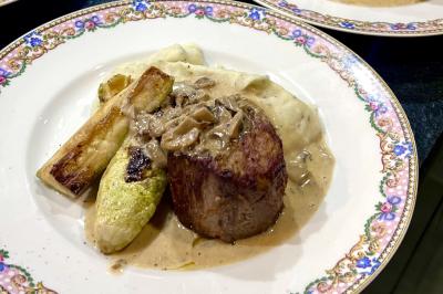 Assiette gastronomique composée de crevettes, légumes, pommes de terre et perles de sauce, présentée avec soin.