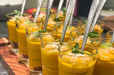 Assiette gastronomique composée de crevettes, légumes, pommes de terre et perles de sauce, présentée avec soin.