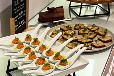 Assiette gastronomique composée de crevettes, légumes, pommes de terre et perles de sauce, présentée avec soin.