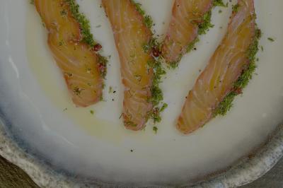 Assiette gastronomique composée de crevettes, légumes, pommes de terre et perles de sauce, présentée avec soin.
