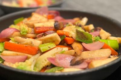 Assiette gastronomique composée de crevettes, légumes, pommes de terre et perles de sauce, présentée avec soin.