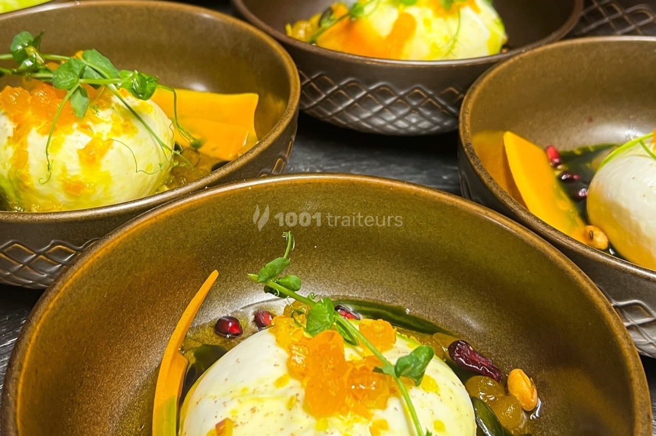 Assiettes en céramique contenant des entrées composées de burrata, légumes, graines et herbes fraîches.