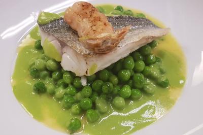 Assiette gastronomique composée de crevettes, légumes, pommes de terre et perles de sauce, présentée avec soin.