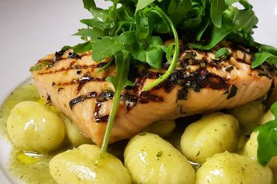 Assiette gastronomique composée de crevettes, légumes, pommes de terre et perles de sauce, présentée avec soin.