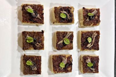 Assiette gastronomique composée de crevettes, légumes, pommes de terre et perles de sauce, présentée avec soin.