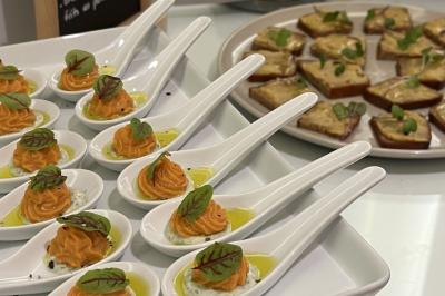 Assiette gastronomique composée de crevettes, légumes, pommes de terre et perles de sauce, présentée avec soin.