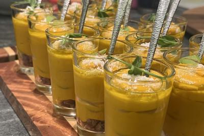Assiette gastronomique composée de crevettes, légumes, pommes de terre et perles de sauce, présentée avec soin.