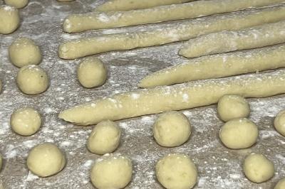 Assiette gastronomique composée de crevettes, légumes, pommes de terre et perles de sauce, présentée avec soin.