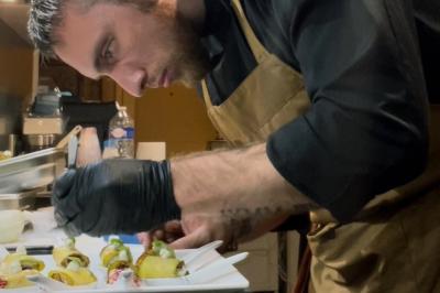 Assiette gastronomique composée de crevettes, légumes, pommes de terre et perles de sauce, présentée avec soin.