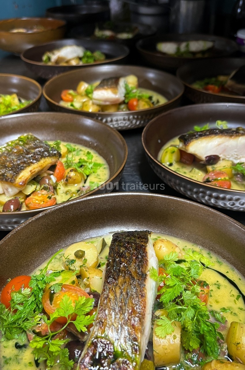 Assiettes de poisson grillé servies avec légumes, pommes de terre, herbes fraîches et sauce crémeuse.