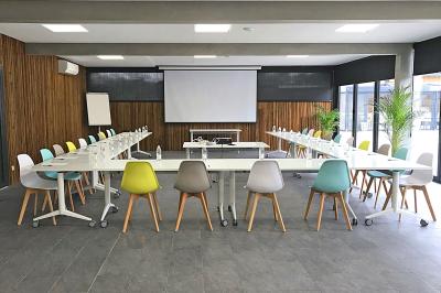 Vue aérienne d'un complexe avec piscines, bâtiments, espaces verts et parkings, entouré de végétation.