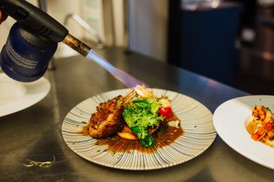 Vue aérienne d'un complexe avec piscines, bâtiments, espaces verts et parkings, entouré de végétation.