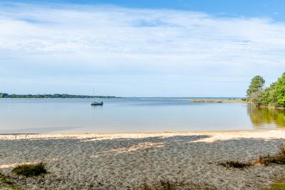 Vue aérienne d'un complexe avec piscines, bâtiments, espaces verts et parkings, entouré de végétation.