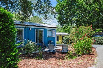 Vue aérienne d'un complexe avec piscines, bâtiments, espaces verts et parkings, entouré de végétation.
