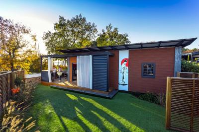 Vue aérienne d'un complexe avec piscines, bâtiments, espaces verts et parkings, entouré de végétation.