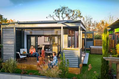 Vue aérienne d'un complexe avec piscines, bâtiments, espaces verts et parkings, entouré de végétation.