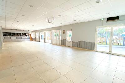 Piscine extérieure avec toboggans, jets d'eau et chaises colorées disposées autour sous un ciel dégagé.