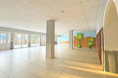Piscine extérieure avec toboggans, jets d'eau et chaises colorées disposées autour sous un ciel dégagé.