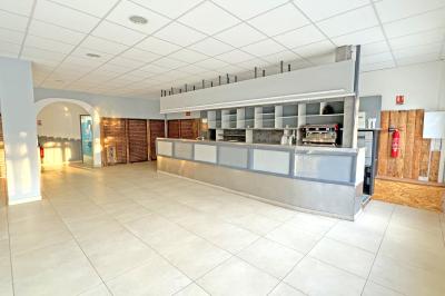 Piscine extérieure avec toboggans, jets d'eau et chaises colorées disposées autour sous un ciel dégagé.