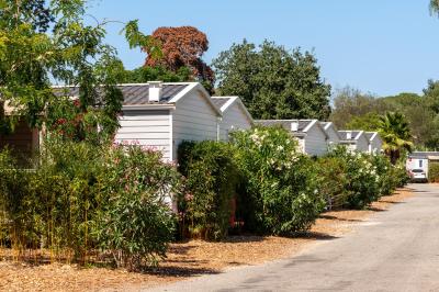 Piscine extérieure avec toboggans, jets d'eau et chaises colorées disposées autour sous un ciel dégagé.