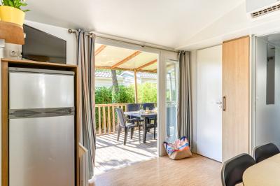 Piscine extérieure avec toboggans, jets d'eau et chaises colorées disposées autour sous un ciel dégagé.