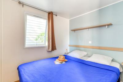 Piscine extérieure avec toboggans, jets d'eau et chaises colorées disposées autour sous un ciel dégagé.