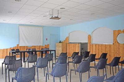 Piscine extérieure avec toboggans, jets d'eau et chaises colorées disposées autour sous un ciel dégagé.