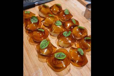 Assiette gastronomique avec saumon, mousse blanche, herbes fraîches et sauce jaune décorée de points verts.