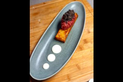 Assiette gastronomique avec saumon, mousse blanche, herbes fraîches et sauce jaune décorée de points verts.