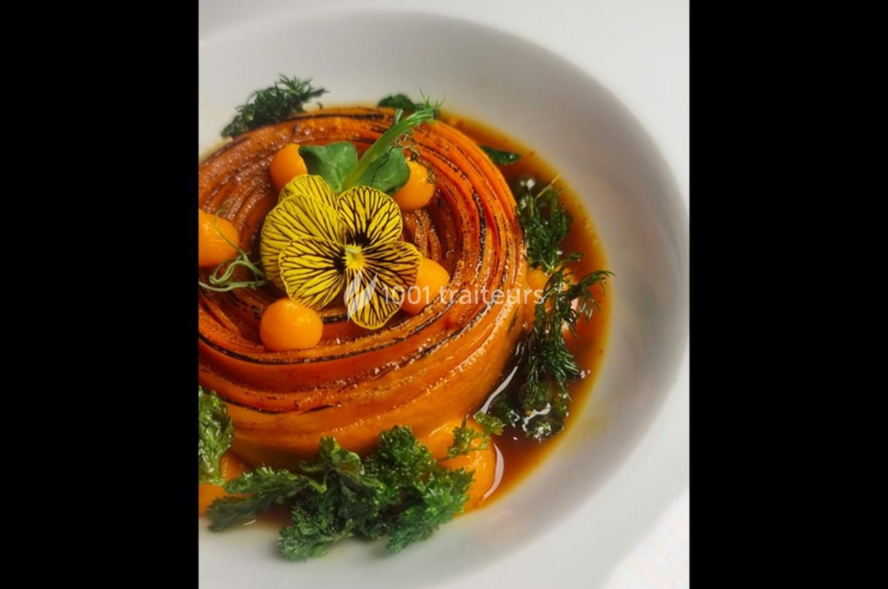 Assiette gastronomique avec une présentation artistique de légumes colorés, herbes fraîches et sauce.