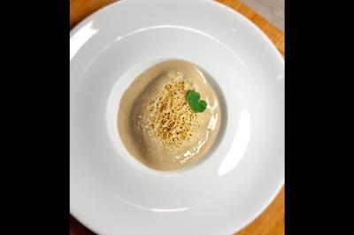 Assiette gastronomique avec saumon, mousse blanche, herbes fraîches et sauce jaune décorée de points verts.