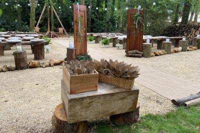Panneau ’Welcome to our happy place’ fixé à un arbre entouré de lierre dans une forêt.