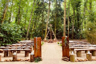 Panneau ’Welcome to our happy place’ fixé à un arbre entouré de lierre dans une forêt.