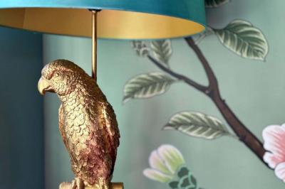 Terrasse en bois aménagée avec des fauteuils, coussins et poufs, entourée d'arbres dans un cadre naturel.