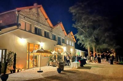 Terrasse en bois aménagée avec des fauteuils, coussins et poufs, entourée d'arbres dans un cadre naturel.