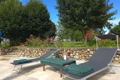 Tables dressées avec nappes blanches et décoration florale sur une terrasse ensoleillée, avec des convives en arrière-plan.