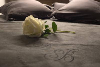 Tables dressées avec nappes blanches et décoration florale sur une terrasse ensoleillée, avec des convives en arrière-plan.