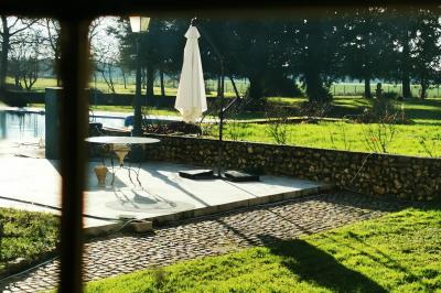 Tables dressées avec nappes blanches et décoration florale sur une terrasse ensoleillée, avec des convives en arrière-plan.