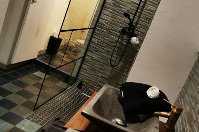 Tables dressées avec nappes blanches et décoration florale sur une terrasse ensoleillée, avec des convives en arrière-plan.